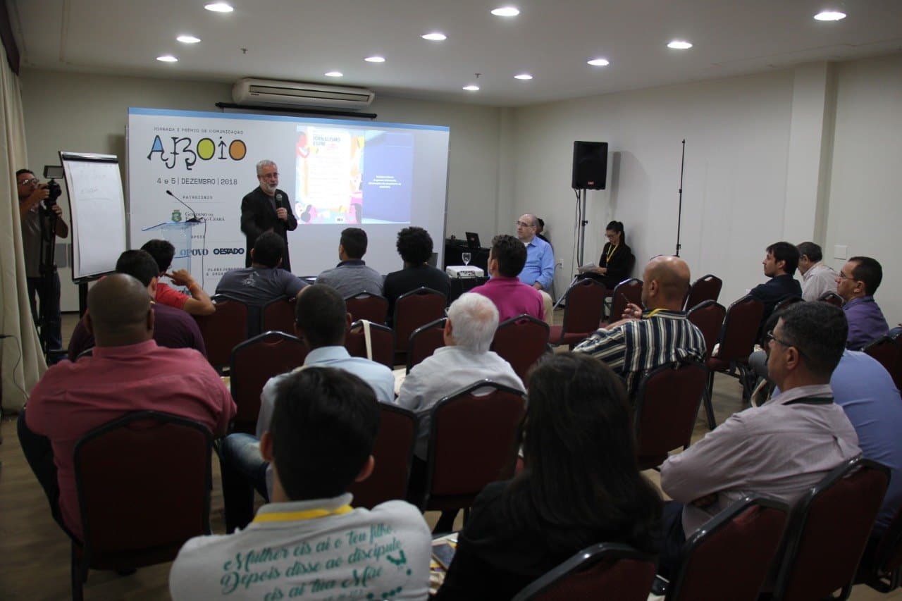 Ruy Jobim de microfone na mão, falando para a plateia da Jornada Aboio, com o telão ao fundo